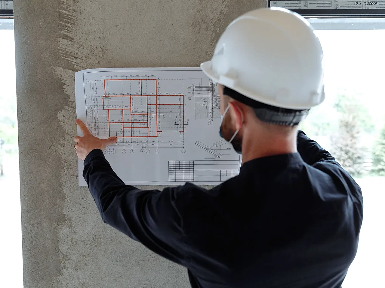 Fachperson bei der Prüfung eines Gebäudeplans